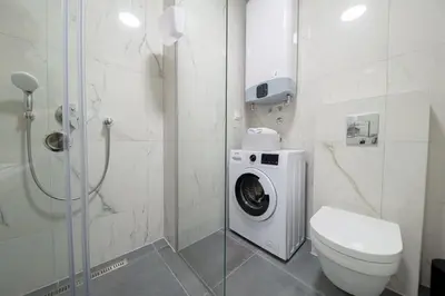 a bathroom with a washing machine and a toilet at DiVa Lux Apartment in Soho City complex in Bar