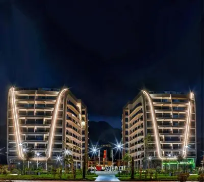 two large buildings at night with lights at DiVa Lux Apartment in Soho City complex in Bar