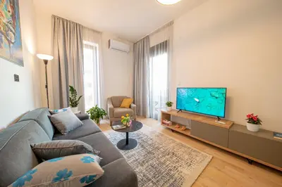 a living room with a couch and a flat screen tv at DiVa Lux Apartment in Soho City complex in Bar