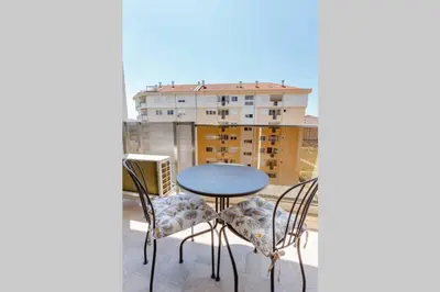a table and chairs on a balcony with a building at Delightful Studio Soho City in Bar