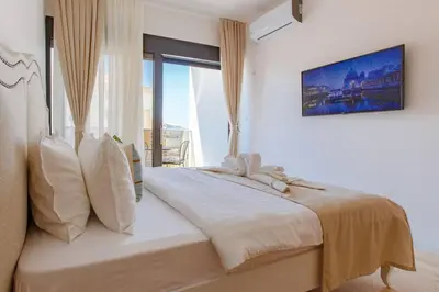 a white bedroom with a large bed with a window at Delightful Studio Soho City in Bar