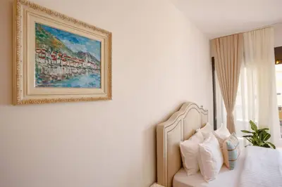 a painting on a wall above a bed with pillows at Delightful Studio Soho City in Bar
