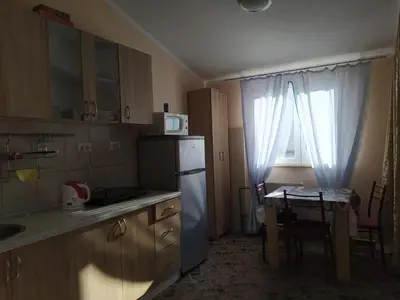 a small kitchen with a table and a refrigerator at MonoLiza in Utjeha
