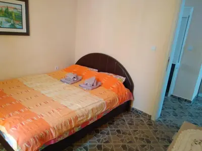 a bedroom with a bed with an orange comforter at MonoLiza in Utjeha
