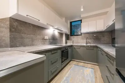 a kitchen with gray and white cabinets and a sink at Atelier in Ulcinj