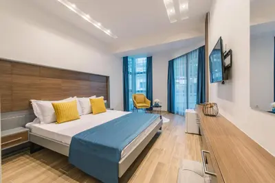 a bedroom with a large bed with yellow pillows at Atelier in Ulcinj