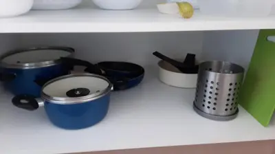 a shelf with several pots and pans on it at Apartments GC 3 in Rafailovici