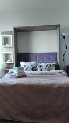 a bedroom with a large bed with a purple headboard at Apartments GC 3 in Rafailovici