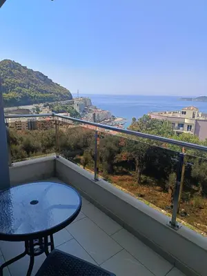 a balcony with a table and a view of the ocean at Apartments GC 3 in Rafailovici