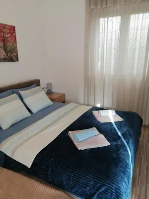 a bedroom with a bed with towels on it at Apartments Željka-Dobrota in Kotor