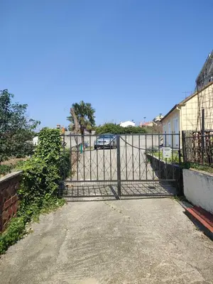 a gate to a parking lot with a car behind it at Apartments Željka-Dobrota in Kotor