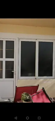 a room with three windows and a red chair at Apartments Željka-Dobrota in Kotor