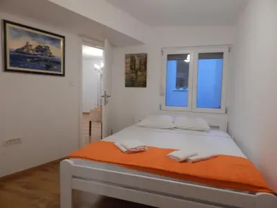 a bedroom with a bed with two towels on it at Sveti Stefan- Apartment Dora in Sveti Stefan