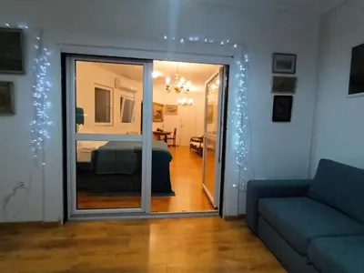 a living room with a couch and a bedroom at Sveti Stefan- Apartment Dora in Sveti Stefan