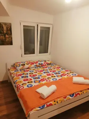 a bed in a room with two towels on it at Sveti Stefan- Apartment Dora in Sveti Stefan