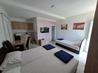 a hotel room with two beds and a kitchen at Apartmani Čavor in Budva