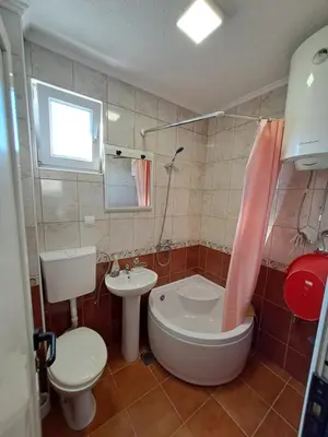 a bathroom with a tub and a toilet and a sink at Apartmani Čavor in Budva