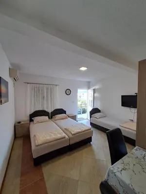 a bedroom with two beds and a flat screen tv at Apartmani Čavor in Budva
