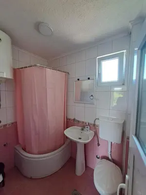 a bathroom with a pink shower curtain and a sink at Apartmani Čavor in Budva