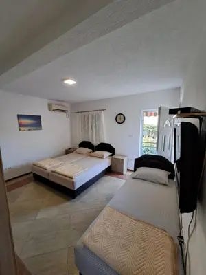 a bedroom with two beds and a window at Apartmani Čavor in Budva