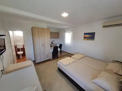 a living room with two beds and a kitchen at Apartmani Čavor in Budva