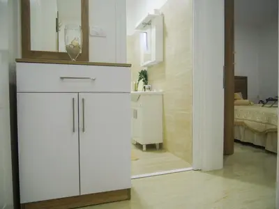 a white cabinet in a room with a bedroom at Imperator Apartments in Ulcinj