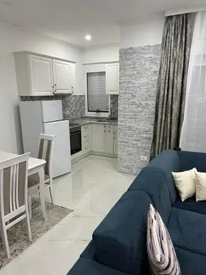 a living room with a blue couch and a kitchen at Imperator Apartments in Ulcinj