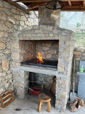 a stone fireplace with a fire in it at Imperator Apartments in Ulcinj