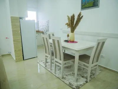 a kitchen with a table and chairs with a plant on it at Imperator Apartments in Ulcinj
