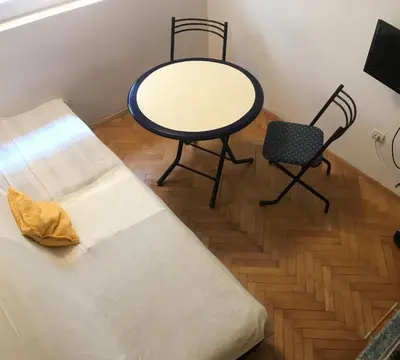 a table and a bench and a table and chair at Apartman Vuk in Budva