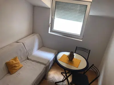 a small living room with a couch and a table at Apartman Vuk in Budva