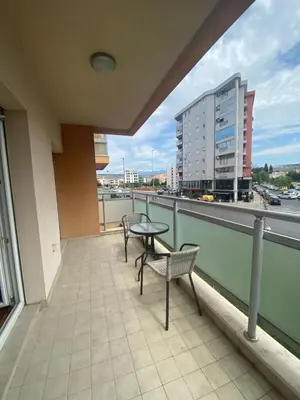 a balcony with two chairs and a table and a building at Apartment Vesna City PG in Podgorica