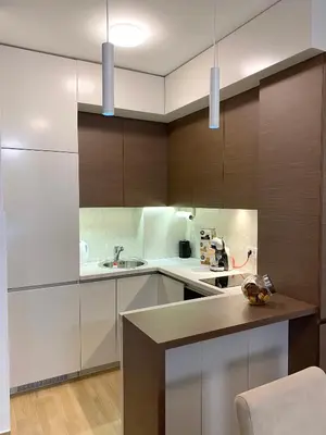 a kitchen with white counters and wooden cabinets at E3 Apartment in Budva
