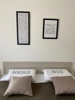 two pillows on a bed with two pictures on the wall at E3 Apartment in Budva