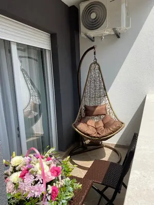 a swing in a room with a table and flowers at E3 Apartment in Budva