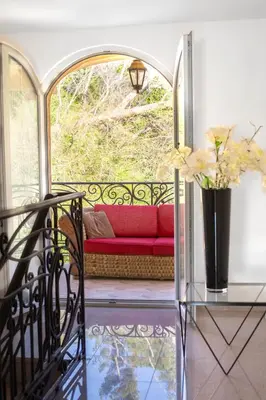 a red couch on a balcony with a vase of flowers at VILA TARA in Sutomore