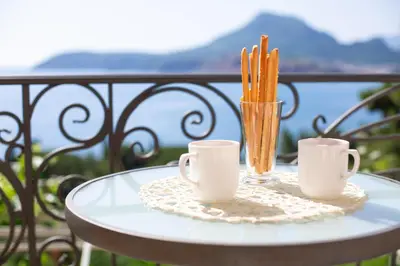 a table with two coffee cups and cinnamon sticks at VILA TARA in Sutomore