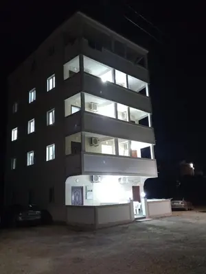 a tall building at night with its lights on at MD APARTMANI CANJ in Čanj