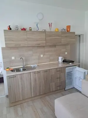 a kitchen with wooden cabinets and a sink at MD APARTMANI CANJ in Čanj