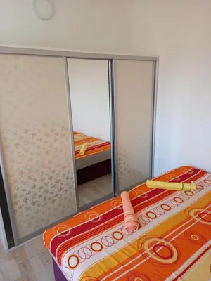 a room with a bed and a mirror at MD APARTMANI CANJ in Čanj
