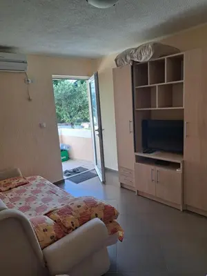 a bedroom with a bed and a sliding glass door at MD APARTMANI CANJ in Čanj