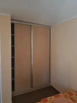 a bedroom with a closet with wooden doors at MD APARTMANI CANJ in Čanj