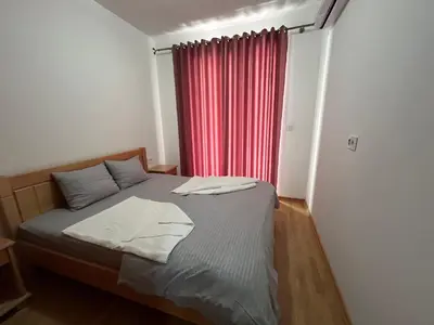 a bed in a room with a red curtain at Apartman Krstajić in Budva