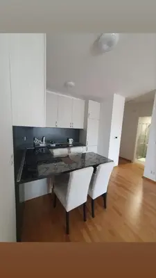 a kitchen with a table and two white chairs at Apartman Krstajić in Budva