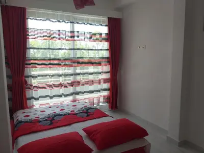 a bedroom with a window with a red curtain at Helena Apartment in Ulcinj
