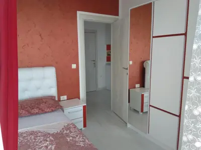 a bedroom with a bed and a mirror at Helena Apartment in Ulcinj
