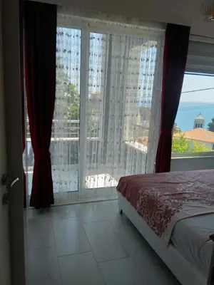 a bedroom with a bed and a large window at Helena Apartment in Ulcinj