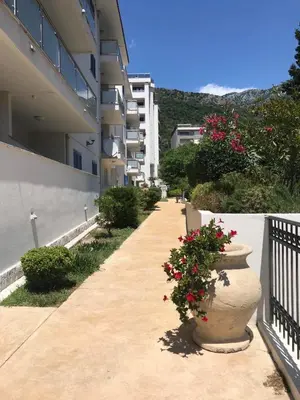 a sidewalk next to a building with flowers in a pot at Adriatic apartman in Becici