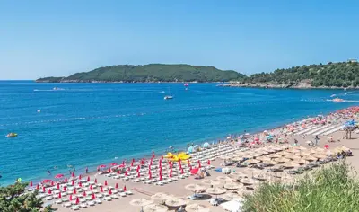 a beach with a bunch of umbrellas and the ocean at Adriatic apartman in Becici