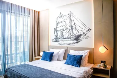 a bedroom with a bed with a drawing of a ship on the wall at Katamare Hotel in Budva
